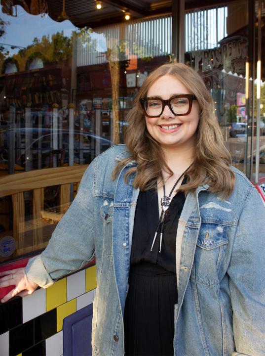 Addie Linn standing in front of a shop.
