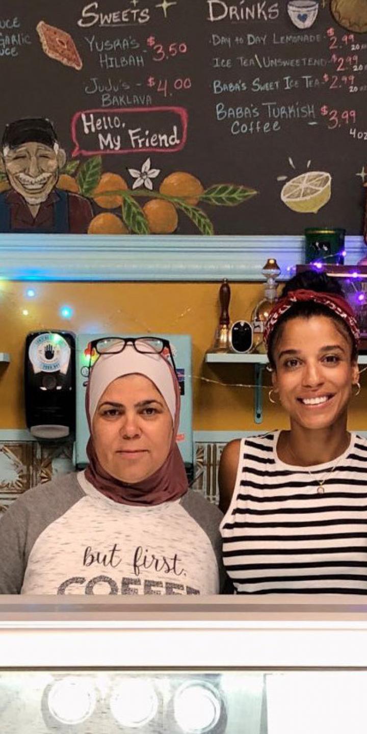 Middle eastern family standing behind a counter at a restaurant