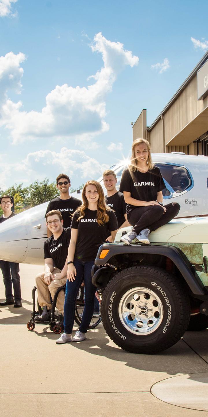 Garmin employees standing next to Jeeps and an airplane