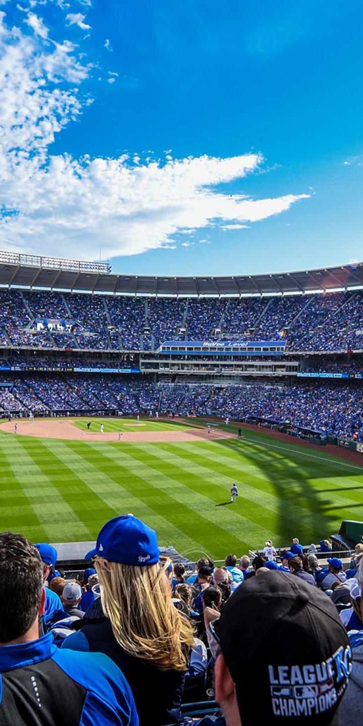 KC Royals baseball team playing at Kauffman stadium on a sunny day, with the stands full of fans