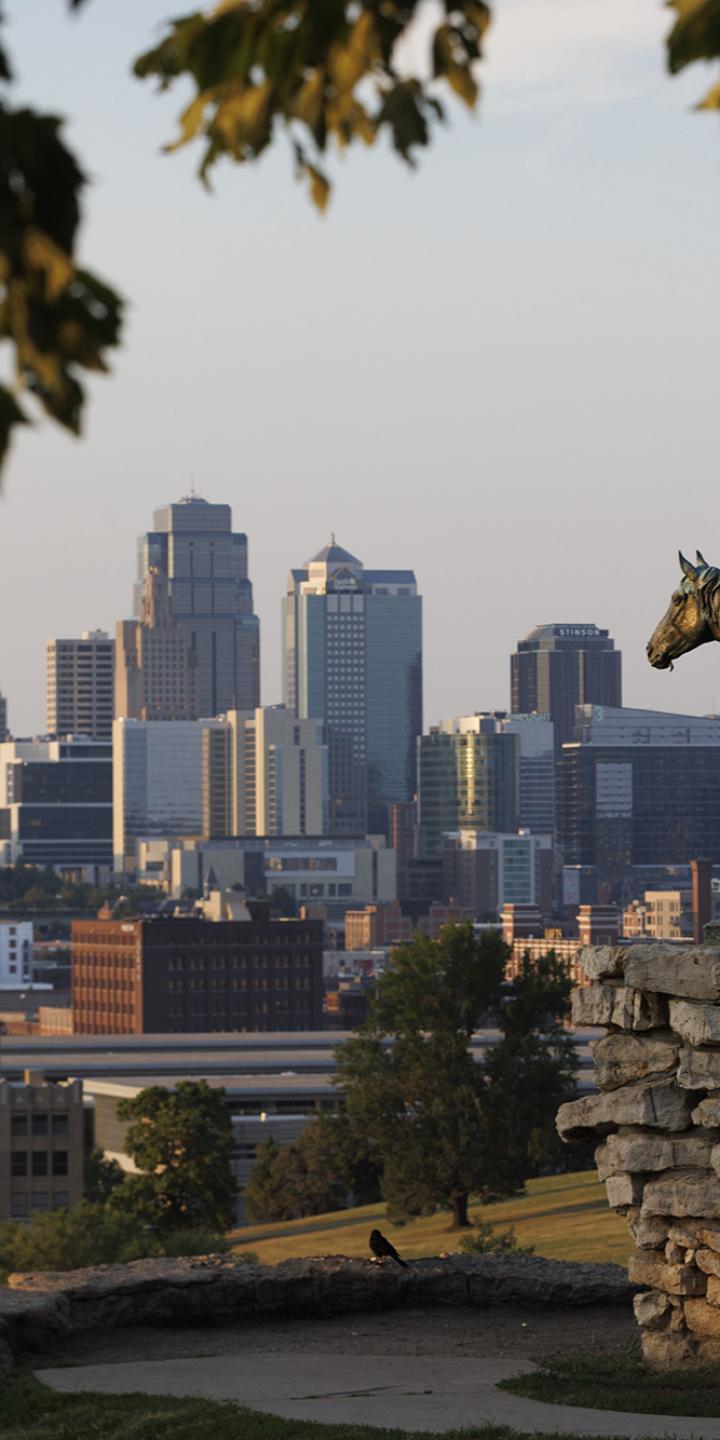 Statue of man on a horse, with the Kansas City skyline in the background