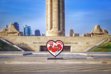 Large heart sculpture with the words "Hope Blooms" and red flowers, in front of Liberty Memorial.